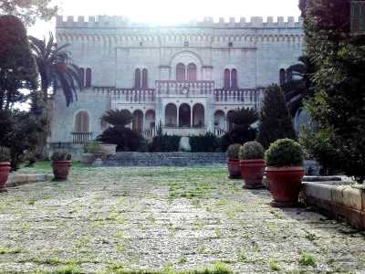 Il prospetto di villa Siciliani: si tratta di una costruzione merlata: ricorda quella di un castello, in pietra color ocra e costellata da ampie finestre strutturate ad archi, che si affacciano su piccoli balconi